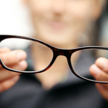 woman hands hold eyeglasses in front of her